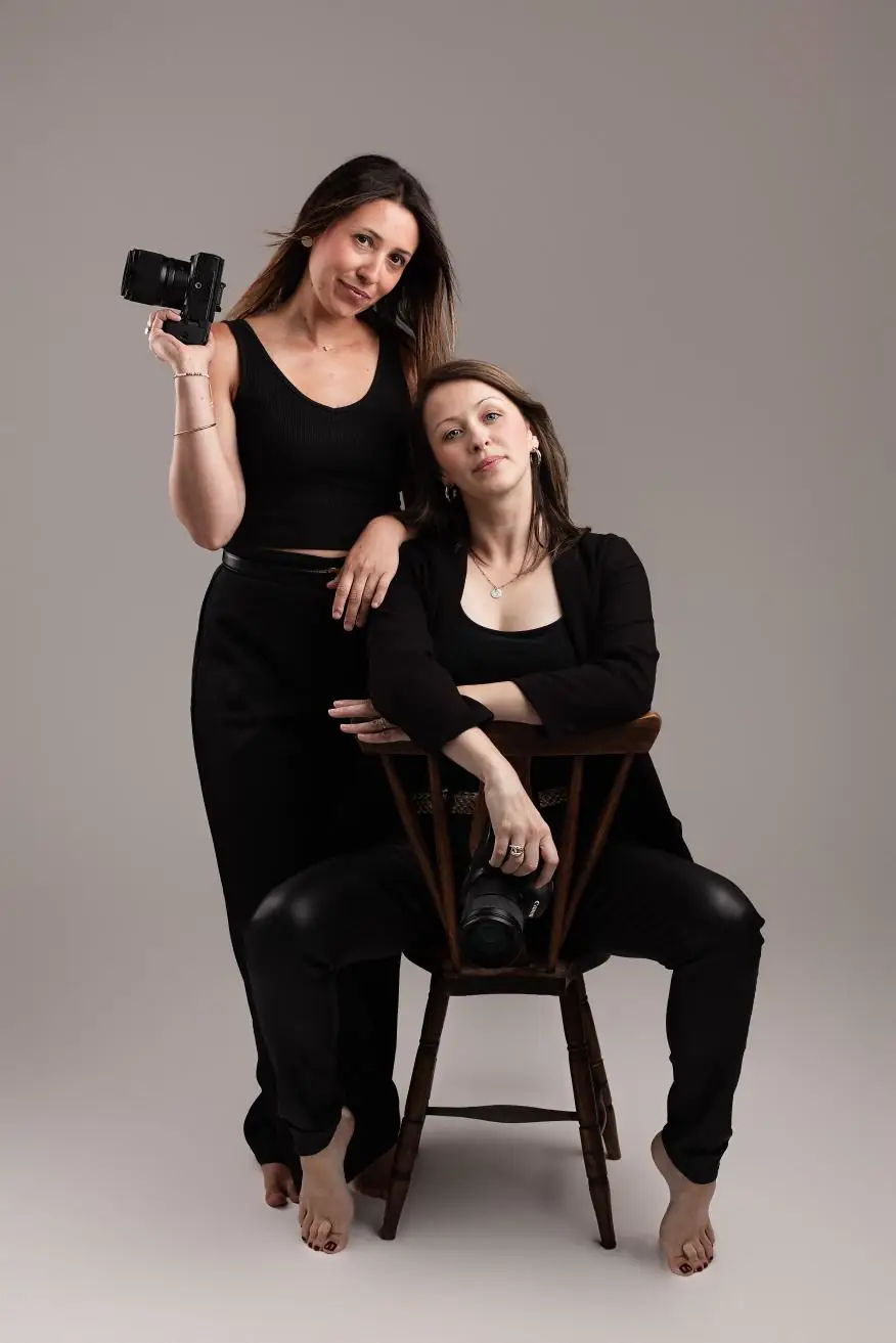 Les deux photographes de L.Studio posant en studio, appareils photo en main